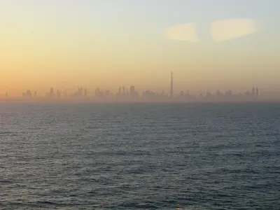 Dubai-Skyline mit Burj Khalifa über dem Wasser in warmer Abenddämmerung