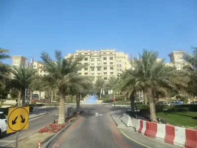 Helles Hotelgebäude mit palmenbegrünter Zufahrt in Dubai