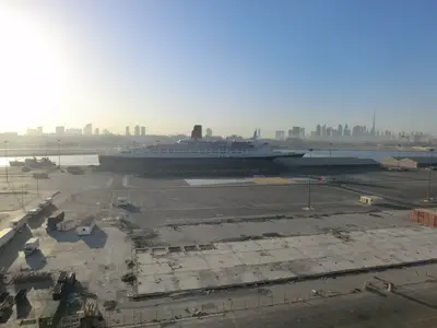 Hafenbecken mit Queen Elizabeth 2 und Skyline von Dubai im Hintergrund
