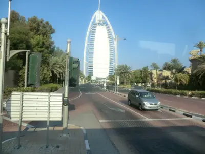 Burj Al Arab hinter Palmen an einer Straße in Dubai
