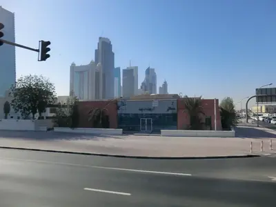 Mehrspurige Straße mit Stadtverkehr vor der Hochhaus-Skyline von Dubai