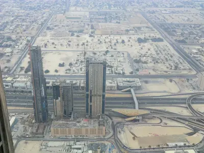 Blick über Dubai mit Straßen, Gebäuden und sandigen Freiflächen am Stadtrand