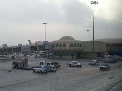 Vorfeld und Terminalgebäude des Flughafens Abu Dhabi mit Fluggastbrücke und Fahrzeugen